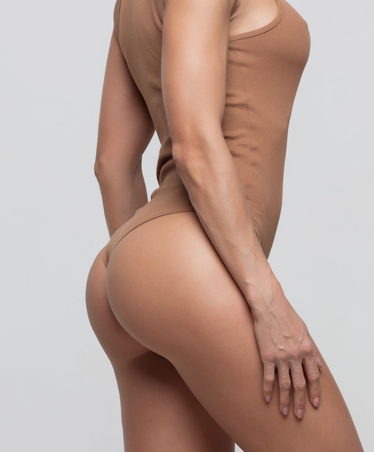 Model posing in seamless bodysuit, side view.