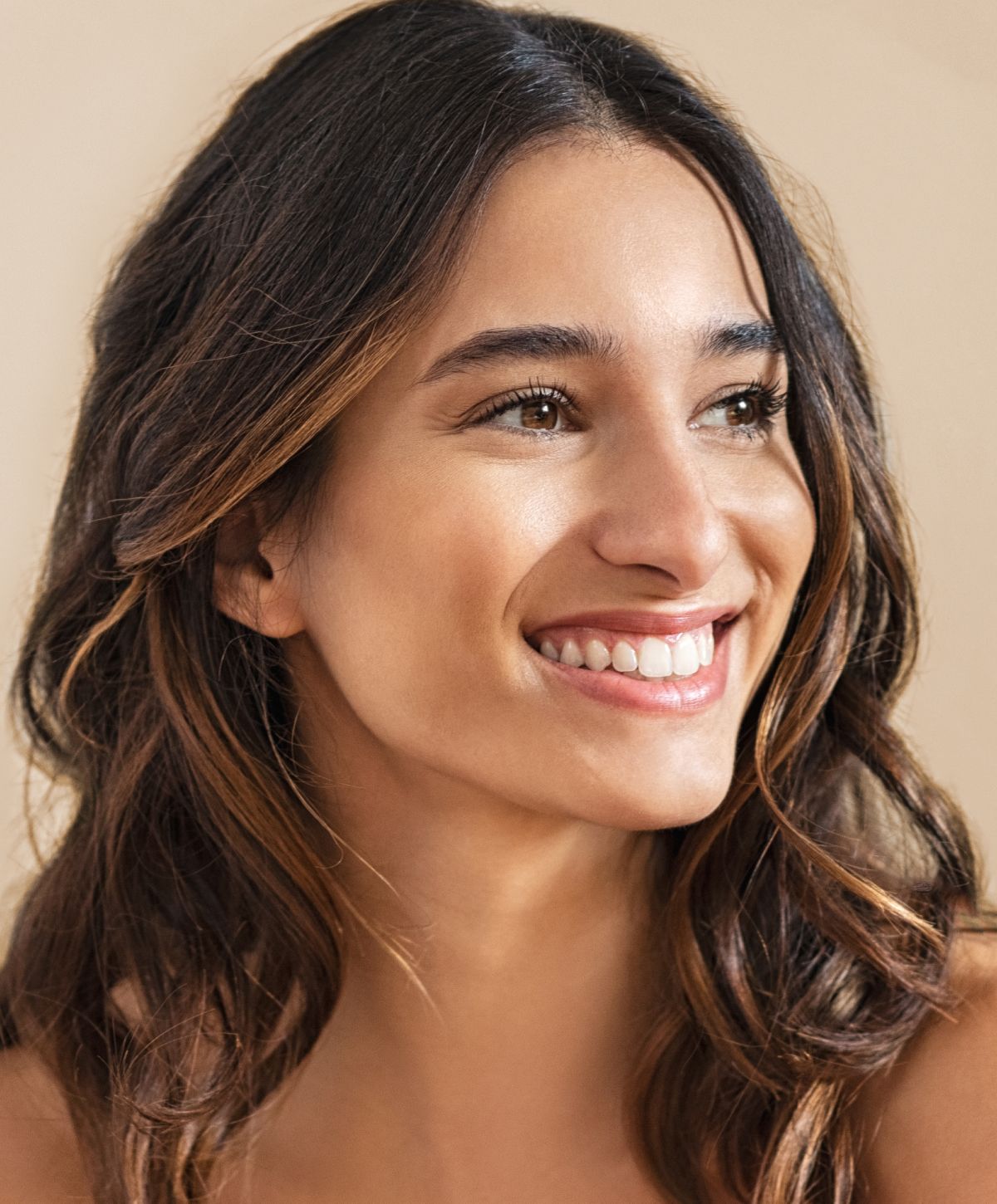 Smiling woman with long, wavy hair.