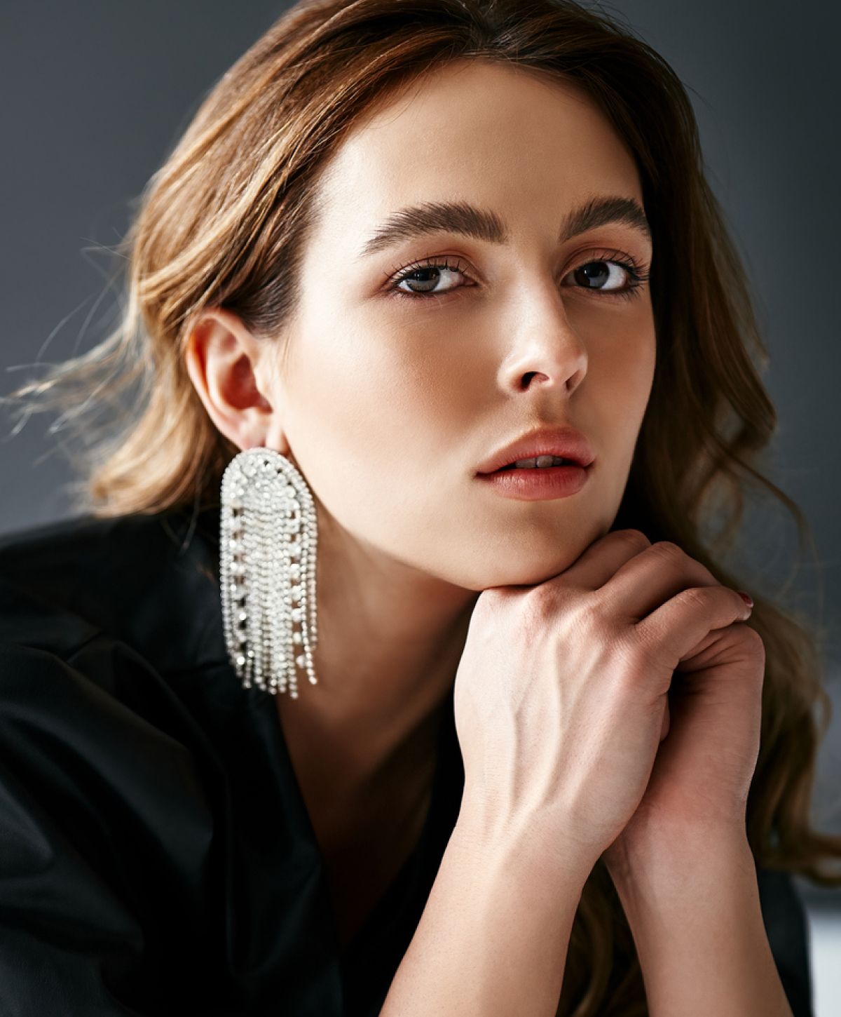 Woman with earrings and soft facial expression.