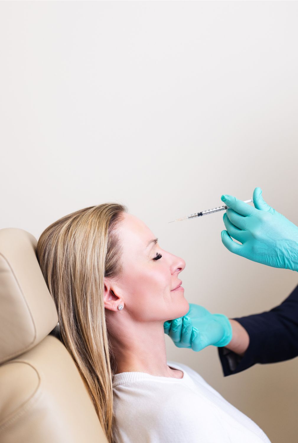 Woman receiving cosmetic injection in medical setting.