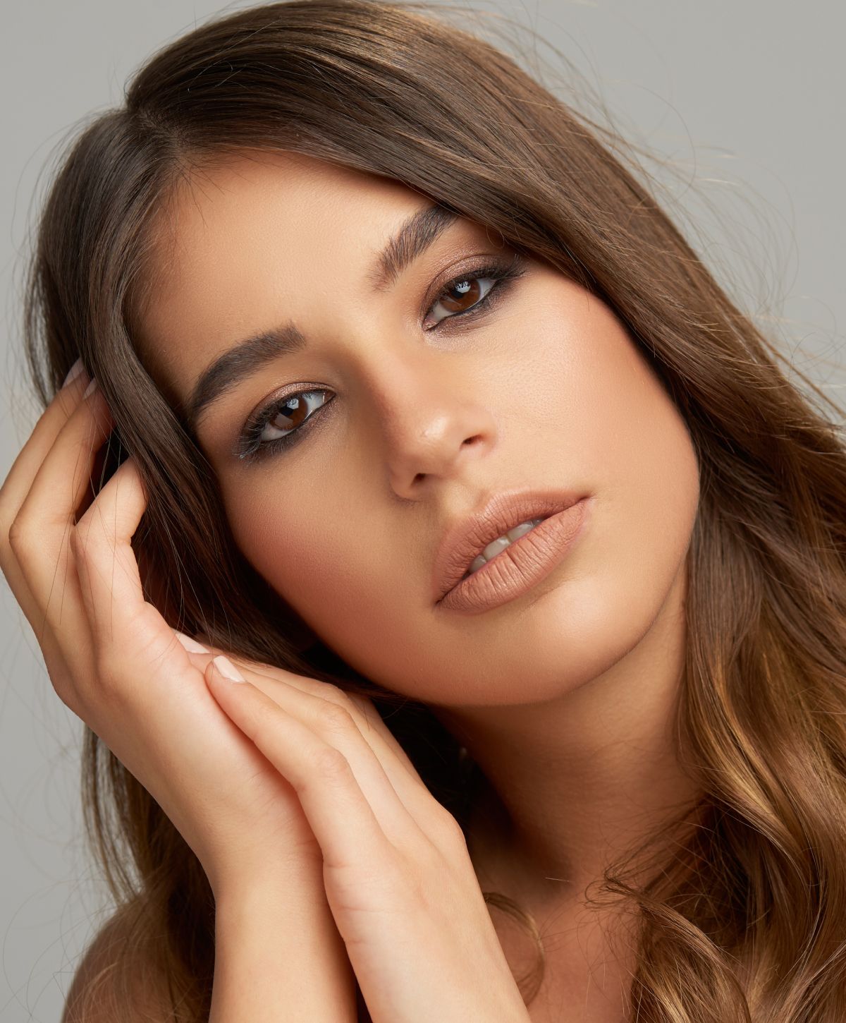 Woman with brown hair holding her hands together