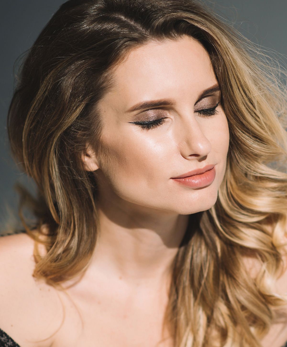 Woman with elegant makeup and soft hairstyle.