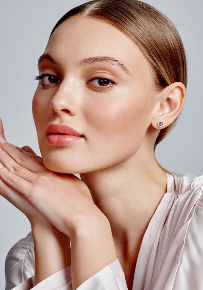 Model showcasing elegant jewelry and soft makeup.
