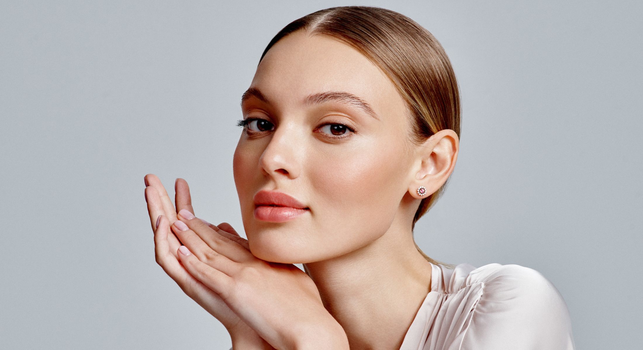 Model posing with hands, elegant expression and style.