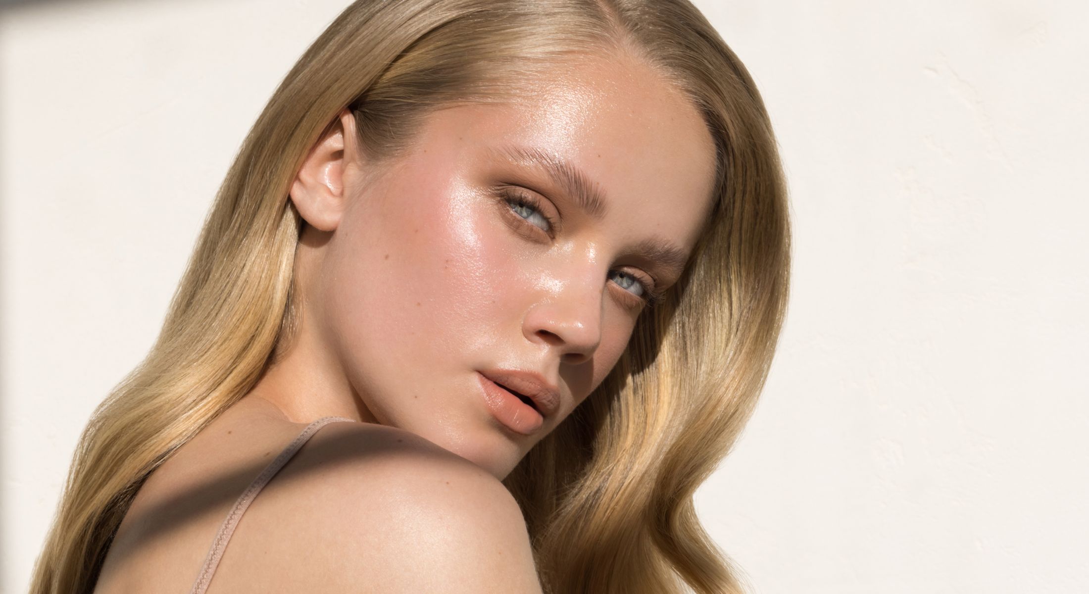 Woman with long hair and glowing skin.