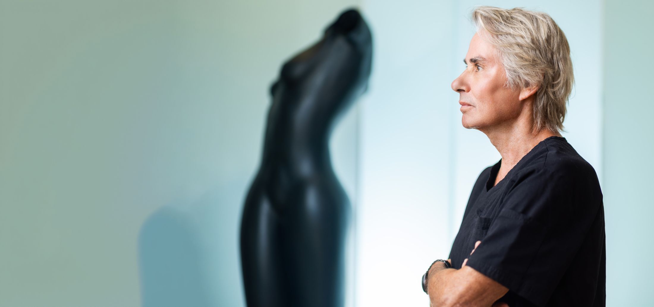 Doctor in scrubs beside a mannequin statue